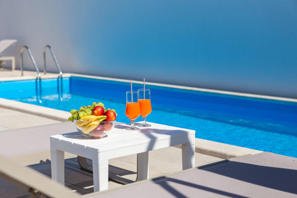 Stol sa sokovima i voćem uz bazen